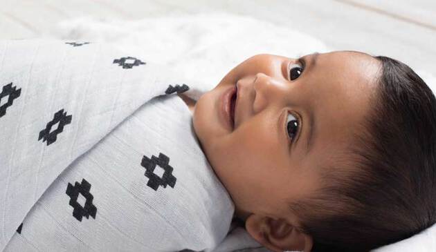 Close up image of baby in Aden + Anais swaddle