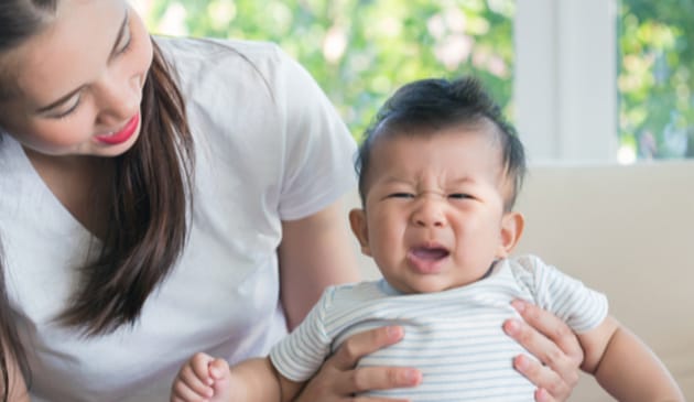 Mum holding crying baby upright