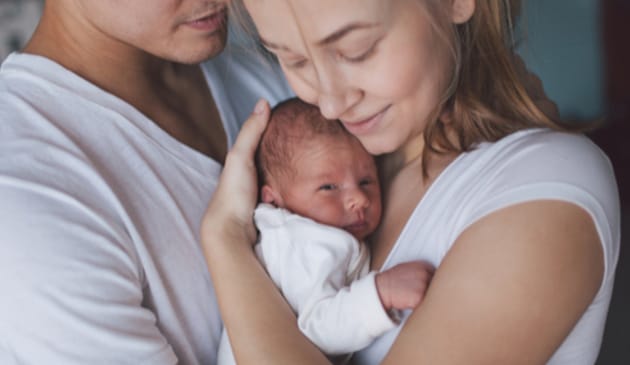 A mum and dad holding new-born baby
