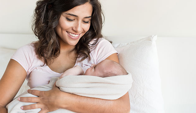 新妈妈抱着新生婴儿