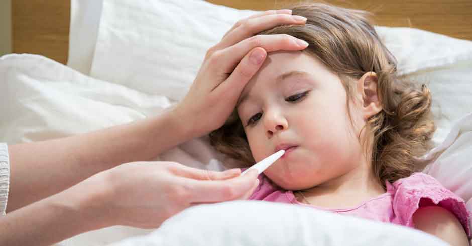 Child in bed having temperature taken with thermometer