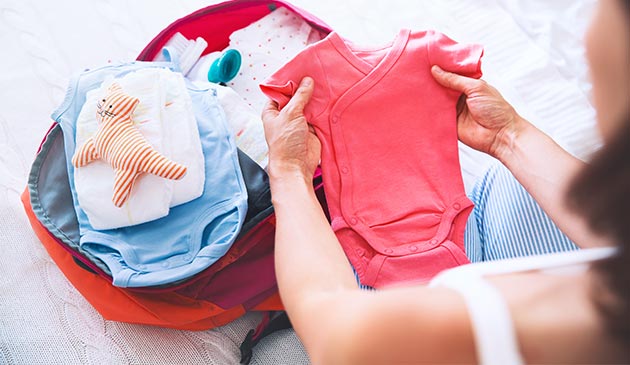 Woman packing hospital bag for newborn