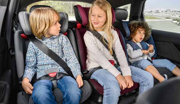 three siblings in car seats