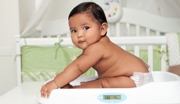 Baby sitting up on scales