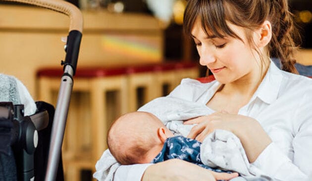 Woman breastfeeding a baby in a cafe