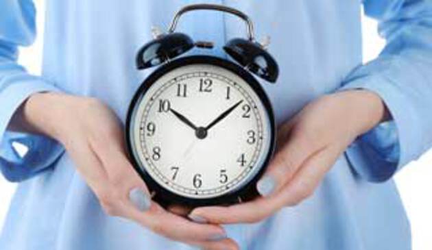 pregnant woman holding a clock